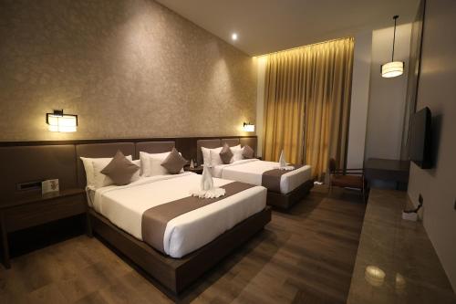 兰奇Vinaika Eco-Resort的一间有两张床和一台电视的酒店房间