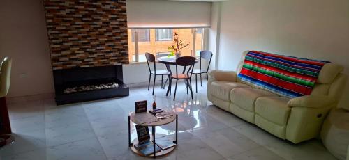 sala de estar con sofá, mesa y chimenea en Colina 804, en Bogotá