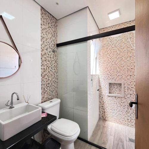 ein Badezimmer mit einer weißen Toilette und einem Waschbecken in der Unterkunft Studio no Centro com ESTACIONAMENTO GRÁTIS in Poços de Caldas