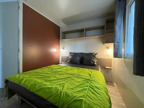 欧雷扬Camping 4 étoiles - Piscine - eecaad的卧室里有一张大床，上面铺着绿色毯子