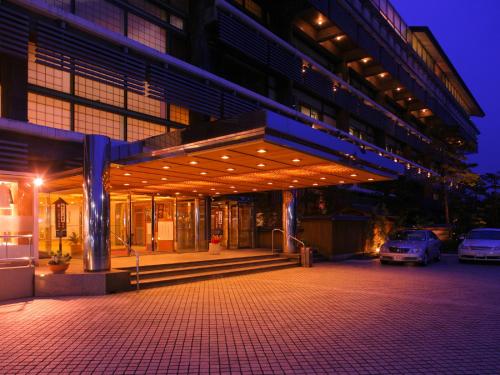 a large building with cars parked in front of it at Grandia Housen in Awara