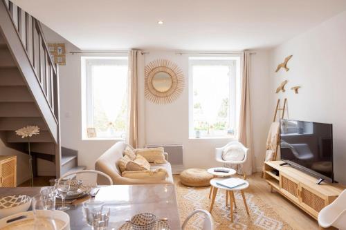 un soggiorno con un divano e una TV di Le Presbytère des Baraques à Blériot-Plage a Sangatte