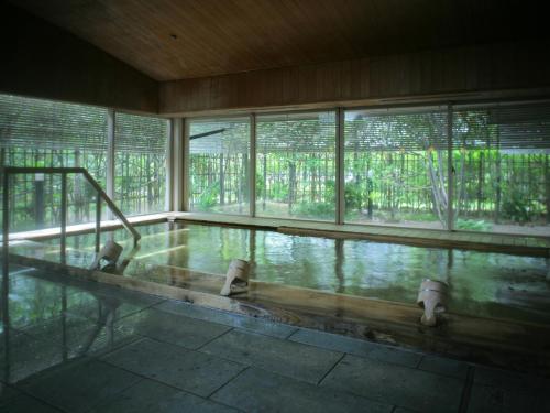 a swimming pool in a building with windows at Grandia Housen in Awara