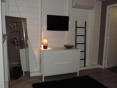 a room with a dresser with a television on the wall at Lukila Bungalow chez Rustine et Pompette in Saint-François