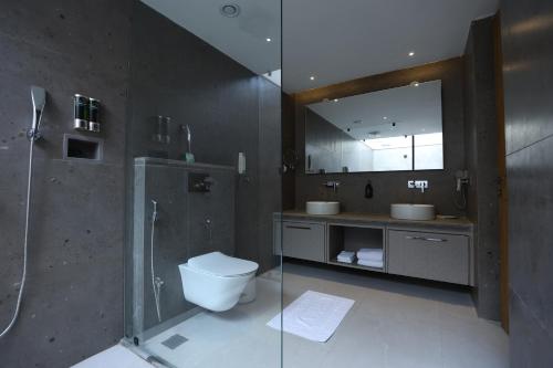 兰奇Vinaika Eco-Resort的带淋浴、卫生间和镜子的浴室