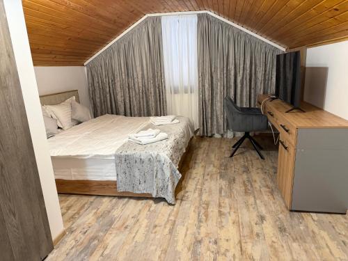 ein Schlafzimmer mit einem Bett und einem Schreibtisch und einem Schreibtisch in der Unterkunft Pensiunea Seraris in Voineasa