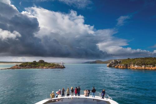 a group of people on a boat in the water at Strahan Retreat Holiday Park in Strahan