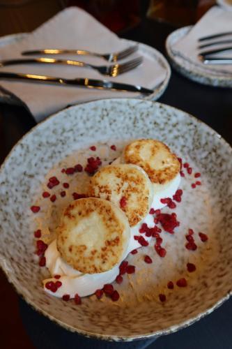a plate of food with pomegranates on a table at Gloria Hotel by YOLO in Szack