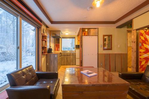 a living room with a table and leather chairs at Hoi Hoi in Rankoshi