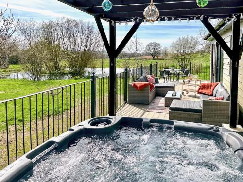 een hot tub op een patio met een hek bij Talltrees - Uk42842 in Uplowman