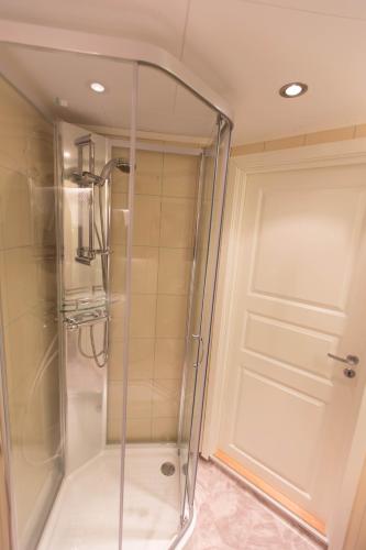 a shower with a glass door in a bathroom at Vannøy Sport og Havfiske in Vannvåg