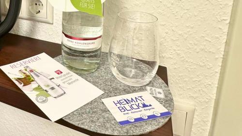 a table with a bottle of water and a glass at Heimatblick Fulda in Fulda
