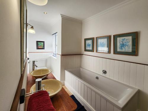 bagno con 2 lavandini e vasca di Living Lagoon Two Apartments a Brenton-on-Sea