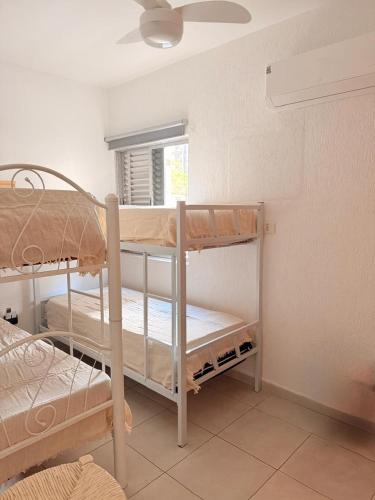 twee stapelbedden in een kamer met een raam bij King Midas in Guarujá