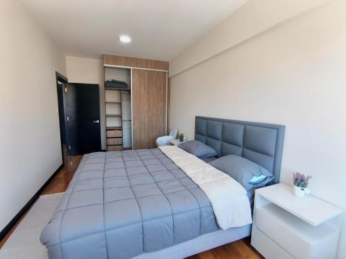 une chambre avec un grand lit et une couverture bleue dans l'établissement SafeHouse, à La Paz