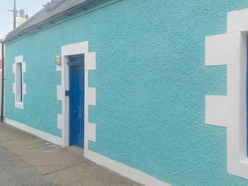 Una pared azul con una puerta azul en un edificio. en Jebel, en Cullen