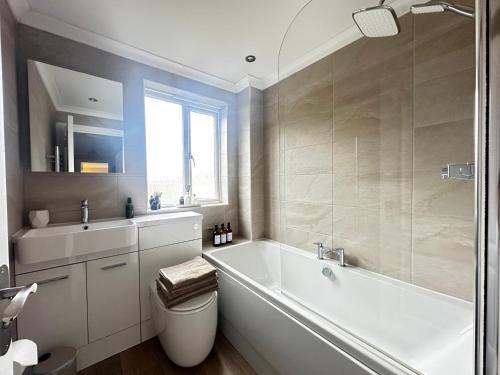 ein Badezimmer mit Badewanne, Toilette und Waschbecken in der Unterkunft Castle View, Cosy Stay in Strood