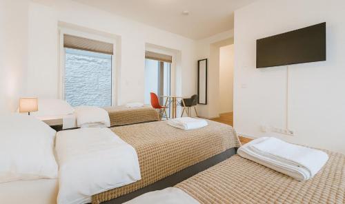 a bedroom with two beds and a flat screen tv at Old Town Apartments in Düsseldorf