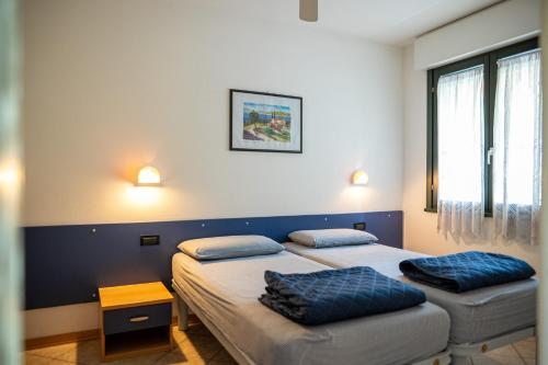 twee bedden in een kamer met twee kussens erop bij Residence Brenta in Bibione