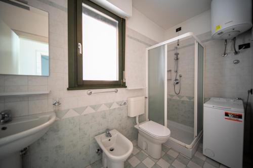 een badkamer met een toilet, een wastafel en een douche bij Residence Brenta in Bibione