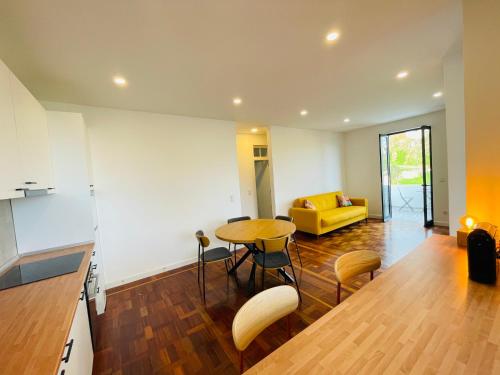 a living room with a table and a yellow couch at Sunny Escape - Ponta do Sol -- Vila Silva Upstairs in Ponta do Sol
