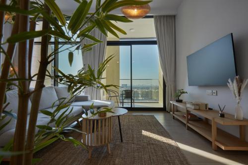 a living room with plants and a flat screen tv at Casa Haven Retreat in Dubai