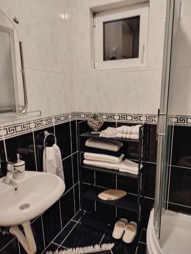 a black and white bathroom with a sink and a mirror at Roza in Ruma