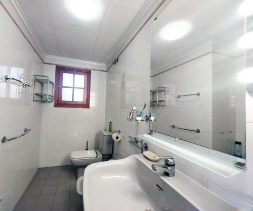 a white bathroom with a sink and a toilet at AGAMARI La Mata Torrevieja sun apartment in Torrevieja