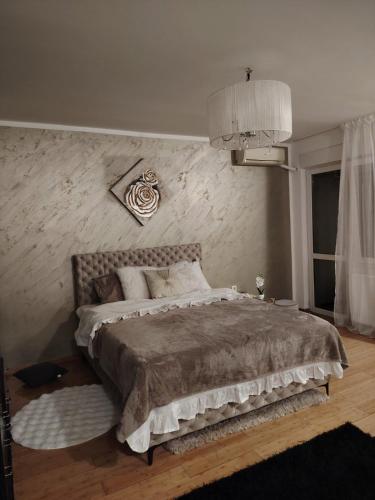 a bedroom with a large bed with a wall at Roza in Ruma