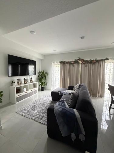 un soggiorno con divano e TV a schermo piatto di Modern room with kitchen and backyard access a Homestead