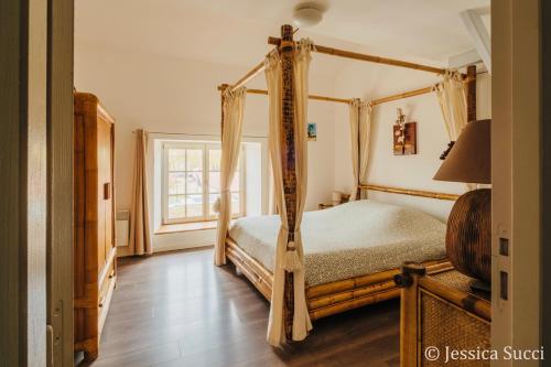 a bedroom with a four poster bed and a window at Superbe appartement type loft en duplex rue Buat in Châlons-en-Champagne