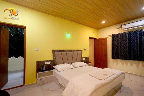 a bedroom with a bed and a yellow wall at The Lyca Resorts in Jog Falls
