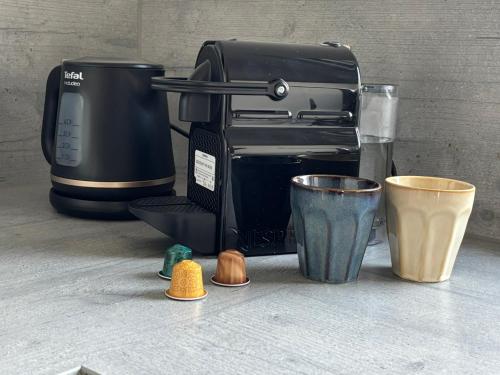 a coffee maker and cups on a counter at Loftbude in Hürth