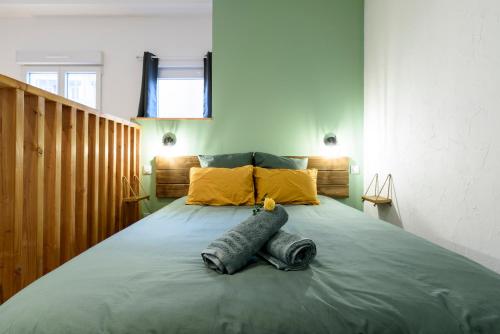 a bedroom with a large bed with blue sheets and yellow pillows at Le Petit Rochalais - Appartement cosy avec terrasse et parking in La Roche-Chalais