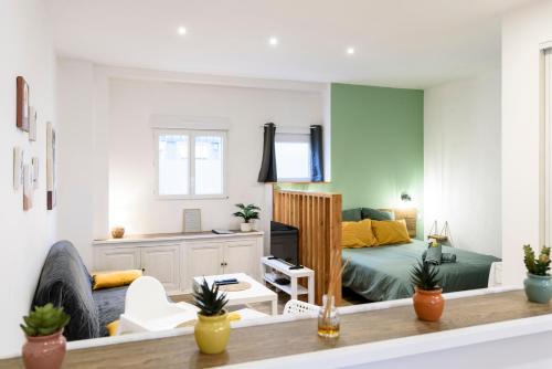 a living room with a bed and a couch at Le Petit Rochalais - Appartement cosy avec terrasse et parking in La Roche-Chalais