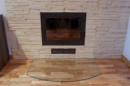 a living room with a stone wall with a flat screen tv at Mēness Apartamenti in Cēsis