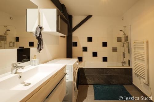 a bathroom with two sinks and a bath tub at Superbe appartement type loft en duplex rue Buat in Châlons-en-Champagne