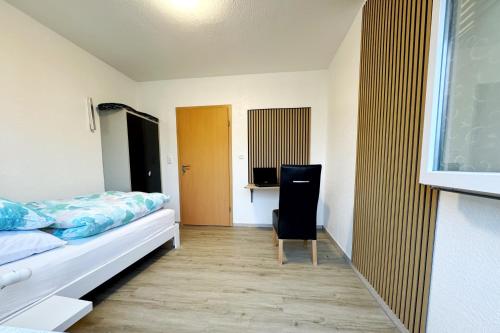 HarpendorfEG Einzel-Apartment - 24h Check In的卧室里有一张床和一把椅子