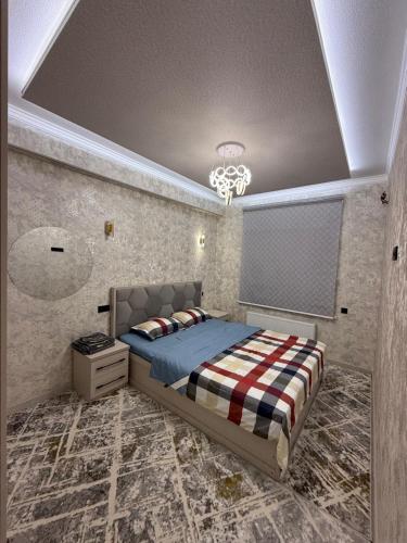 Un dormitorio con una cama y una lámpara de araña en Kvartira, en Irvadan