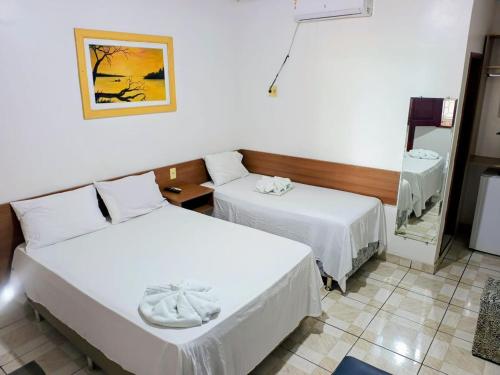 een hotelkamer met twee bedden en een spiegel bij Novo Hotel & Restaurante in Manacapuru
