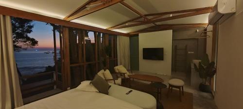 a bedroom with a bed and a view of the ocean at Pebble Lanta - Seaview Stay in Ko Lanta