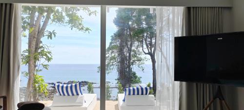 a living room with a large window with a view of the ocean at Pebble Lanta - Seaview Stay in Ko Lanta