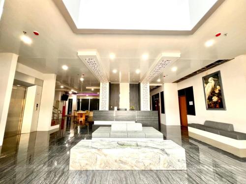 Una habitación grande con un sofá y una cama. en The Grand Hotel Ciamis, en Ciamis