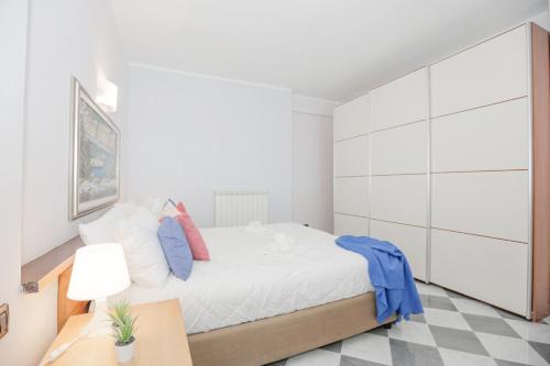 a white bedroom with a large bed and a desk at Polanesi Sea View - Garden - AC - Free Park - Super Wi Fi in Sori