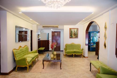 un soggiorno con sedie verdi e tavolo di Hotel Altos del Norte a San Miguel de Tucumán