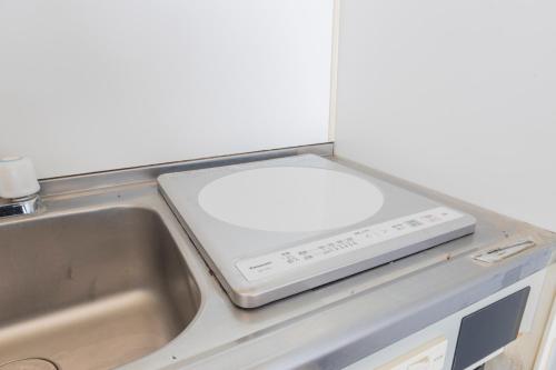 a kitchen counter with a scale on top of a sink at The Nest Koenji Cozy Stay near Station Easy Access to Shinjuku in Tokyo