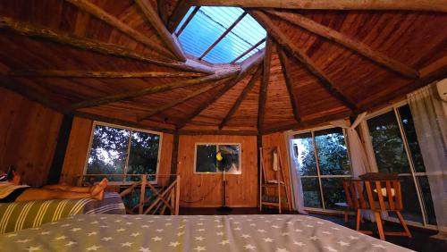 een kamer met een groot houten plafond en ramen bij El octógono in Tigre