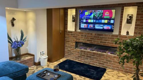 麦克尔斯菲尔德Wonky 2 A Cosy Hideaway in the Heart of Cheshire的带壁炉和平板电视的客厅