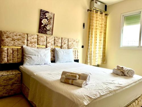 非斯Appart Hotel Fes - Joud Families & Travelers的卧室里有一张大床，床上铺着毛巾。