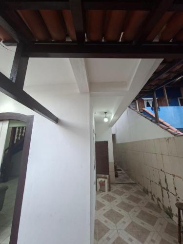 Casa de Hospedagem Flores Paraty 2 في باراتي: ممر علوي ذو جدران بيضاء وسقف خشبي